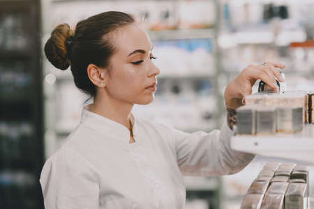 Woman pharmacist checking medicine in pharmacyの写真素材