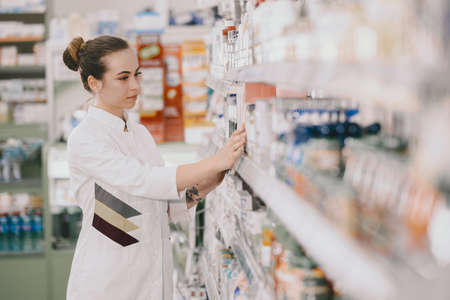 Woman pharmacist checking medicine in pharmacyの写真素材