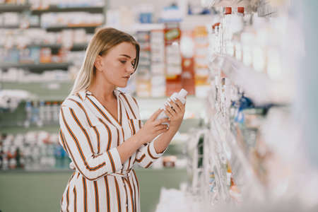 Woman checking medicine in pharmacyの写真素材