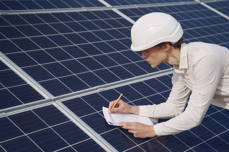 Businessman in a white helmet near solar battery