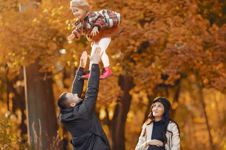 Family with little daughter in a autumn parkの写真素材