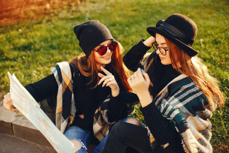 two young girls walk around the city in the autumn city and park