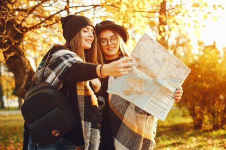 two young girls walk around the city in the autumn city and parkの写真素材