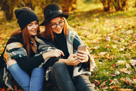 two young girls walk around the city in the autumn city and park
