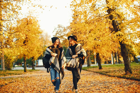 two young girls walk around the city in the autumn city and park