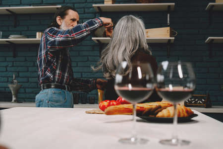 Smiling senior couple dancing in modern kitchenの写真素材