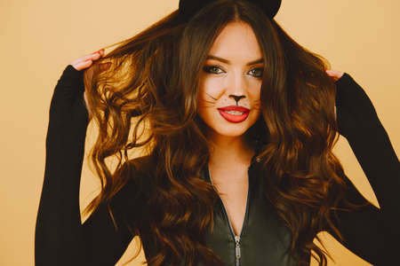 Woman with cat makeup and ears on color backgroundの写真素材
