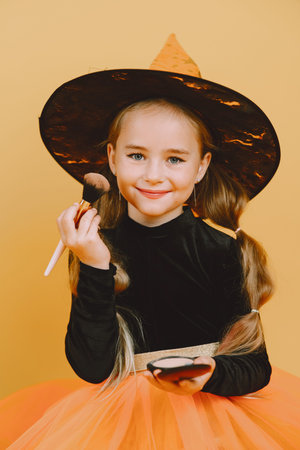 Little girl in costume apply make up on haloween