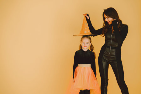 Mother and daughter in haloween costumes pose isolated