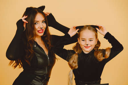 Mother and daughter in haloween costumes pose isolatedの写真素材