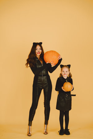 Mother and daughter in haloween costumes pose isolatedの写真素材