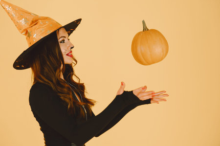 Young woman in haloween costume pose on color background