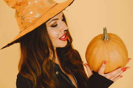 Young woman in haloween costume pose on color backgroundの写真素材