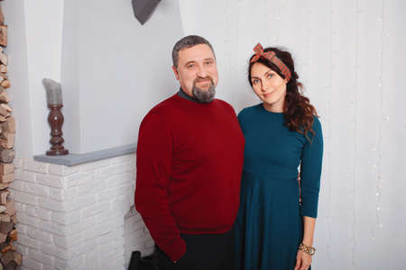 Adult family standing in a room near fireplaceの写真素材