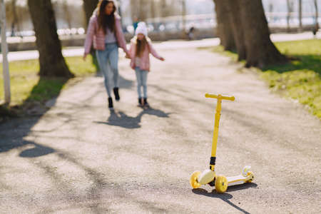 Mother with daughter in a spring park with skateの写真素材