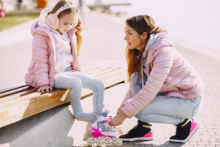 Mother with daughter in a spring park with roller