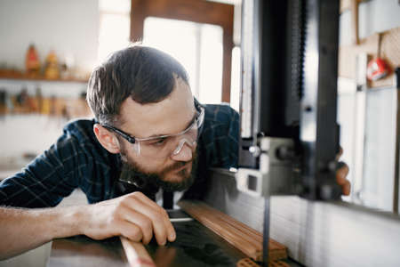 Professional carpenter working with sawing machineの写真素材