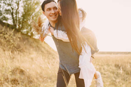 Happy couple in love in wheat field at sunsetの写真素材