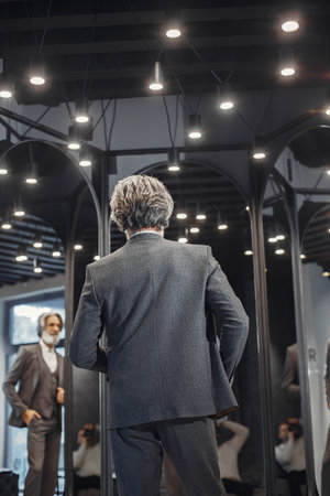 Senior man choosing a new suit in a storeの写真素材