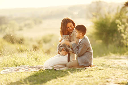 Mother with little son playing in a summer fieldの素材 [FY310173806174]