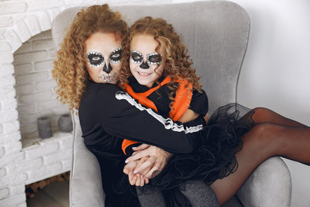 Mother with daughter in a halloween costume and makeup