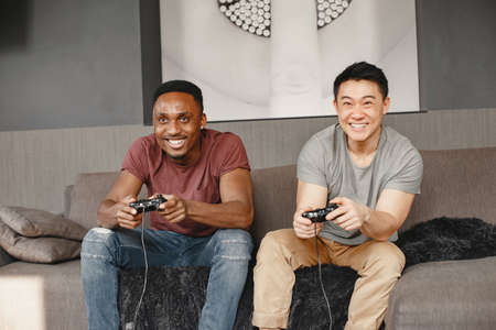 Two friends playing in the living roomの写真素材