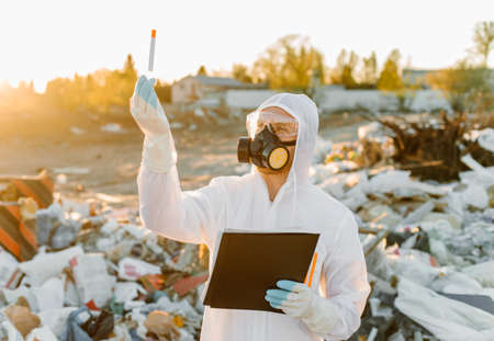 Researcher looking at plastic landfill analyzing environmental pollution levelの写真素材