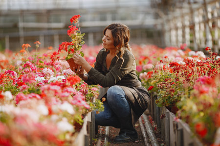 Woman in a green shirt working in a greenhouseの写真素材
