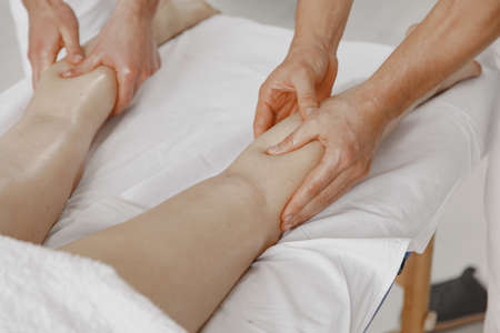 Four hands do massage to female bodyの写真素材