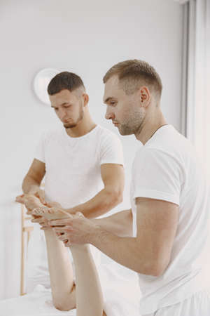 Four hands do massage to female bodyの写真素材