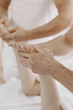 Four hands do massage to female bodyの写真素材