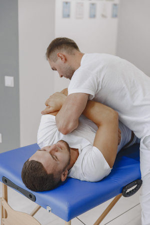 Male physiotherapist massaging mans back