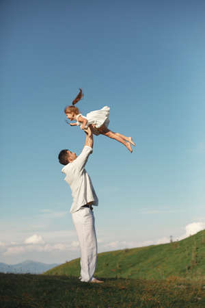 Father playing with ittle daughter in a mountainsの写真素材