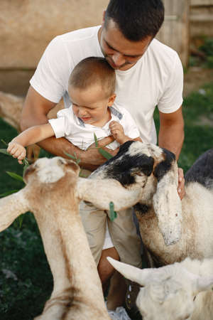 Family spending time together outside with a goatの写真素材
