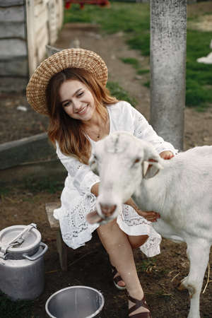 Putdoor portrait of young happy woman with goatの写真素材