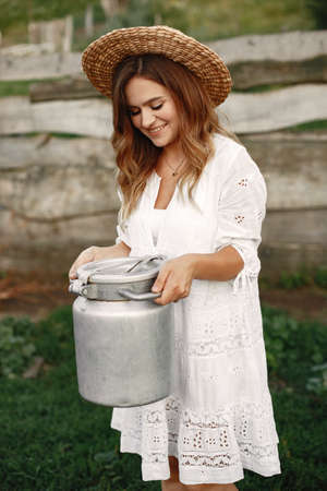 Stylish woman sholdinh barrel with milk in her handsの写真素材
