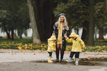 Funny kids in rain boots playing in a rain parkの写真素材