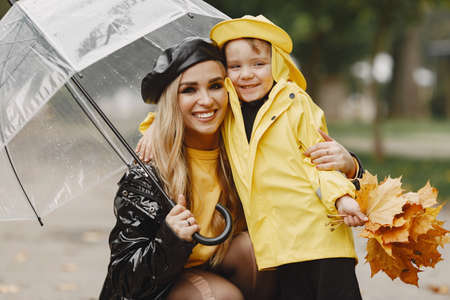 Funny kids in rain boots playing in a rain parkの写真素材