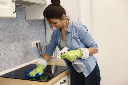 Woman with sponge and rubber gloves cleaning houseの写真素材