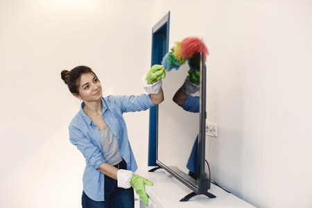 Woman with sponge and rubber gloves cleaning houseの写真素材