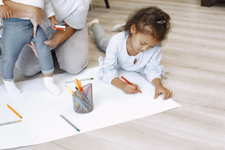 African-american girl lying on floor and drawing with mother.の写真素材