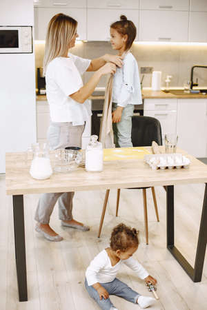 Loving young mother or nanny teach little kid prepare food at home kitchenの写真素材