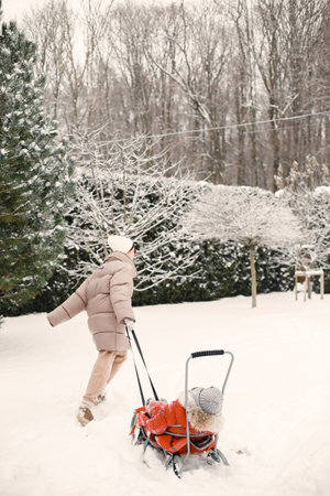 Mother and child in winter clothes play at the yard
