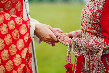 hindu bride walks behind husband holding garbの写真素材