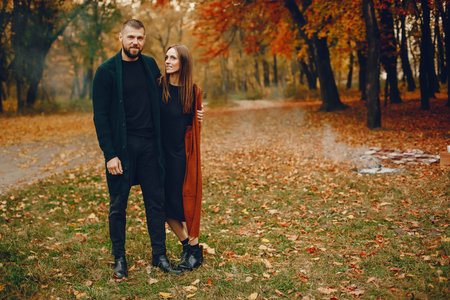Elegant couple spend time in a autumn park
