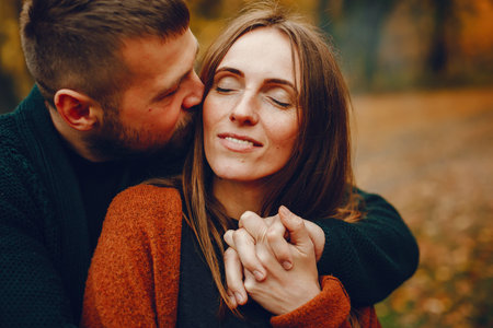 Elegant couple spend time in a autumn park