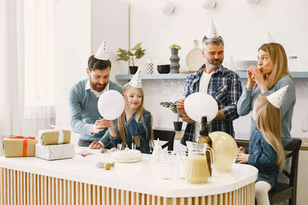 Family celebrating birthday in the kitchenの写真素材
