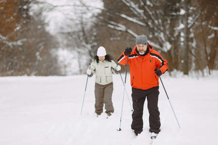 Senior couple skiing cross-country in a forestの写真素材