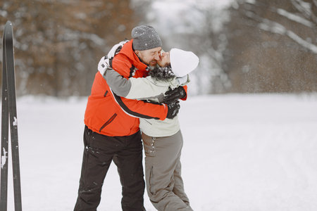 Senior couple skiing cross-country in a forest