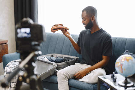 African male blogger recording vlog on digital cameraの写真素材